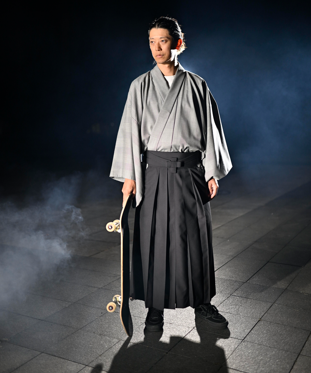 スケートボードを手にした袴スタイルの男性